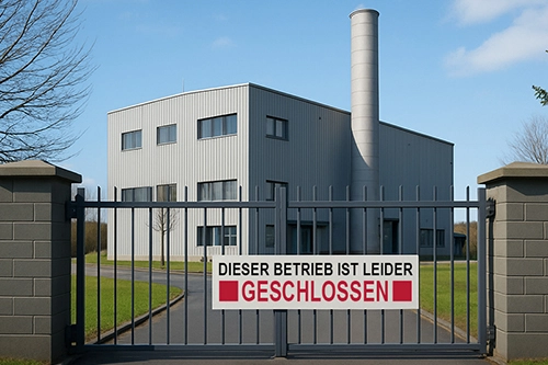 Ein Fabrikgebäude hinter einem Tor mit einem »Geschlossen«-Schild 